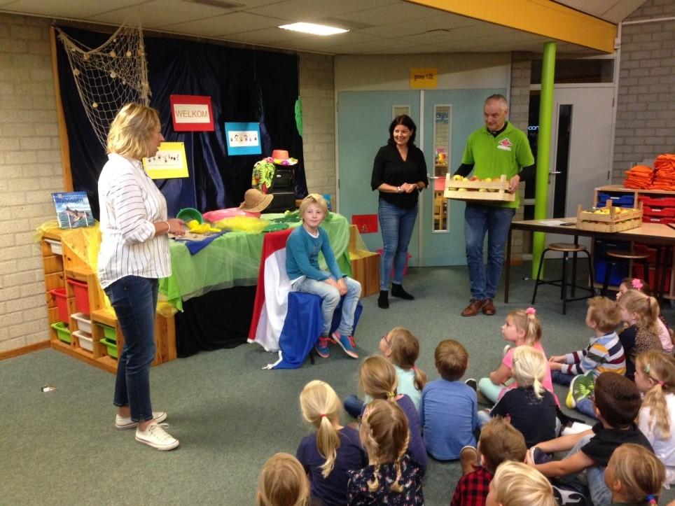 snelste jongen uit olst-wijhe van de appelloop krijgt een kist appels uitgereikt op zijn school